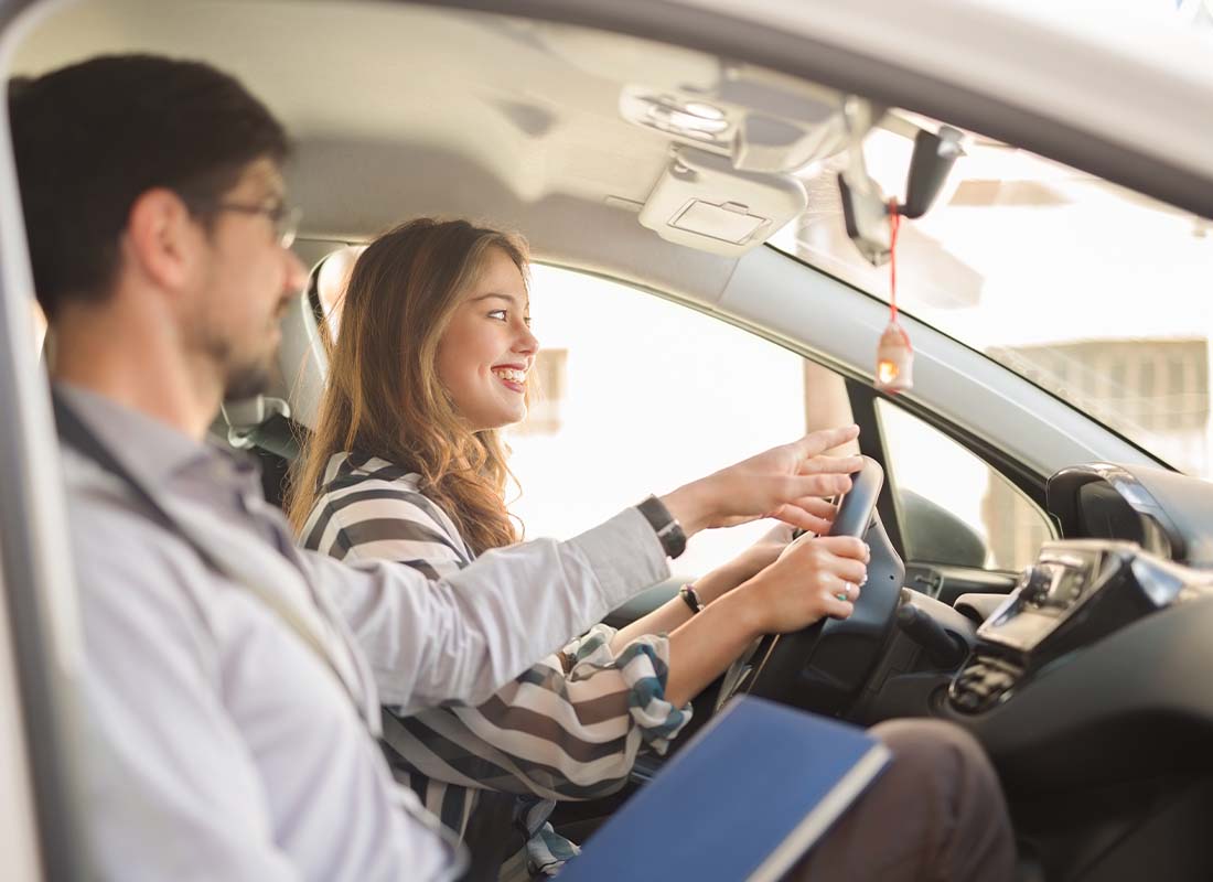 Driving School Insurance - Young Woman Taking a Driving Test With Her Instructor on a Sunny Day